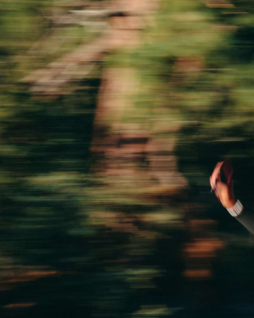 Motion-blurred runner in pink shorts against green hillside